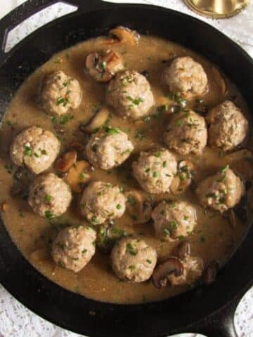 polish meatballs with gravy and mushrooms in a cast iron skillet.