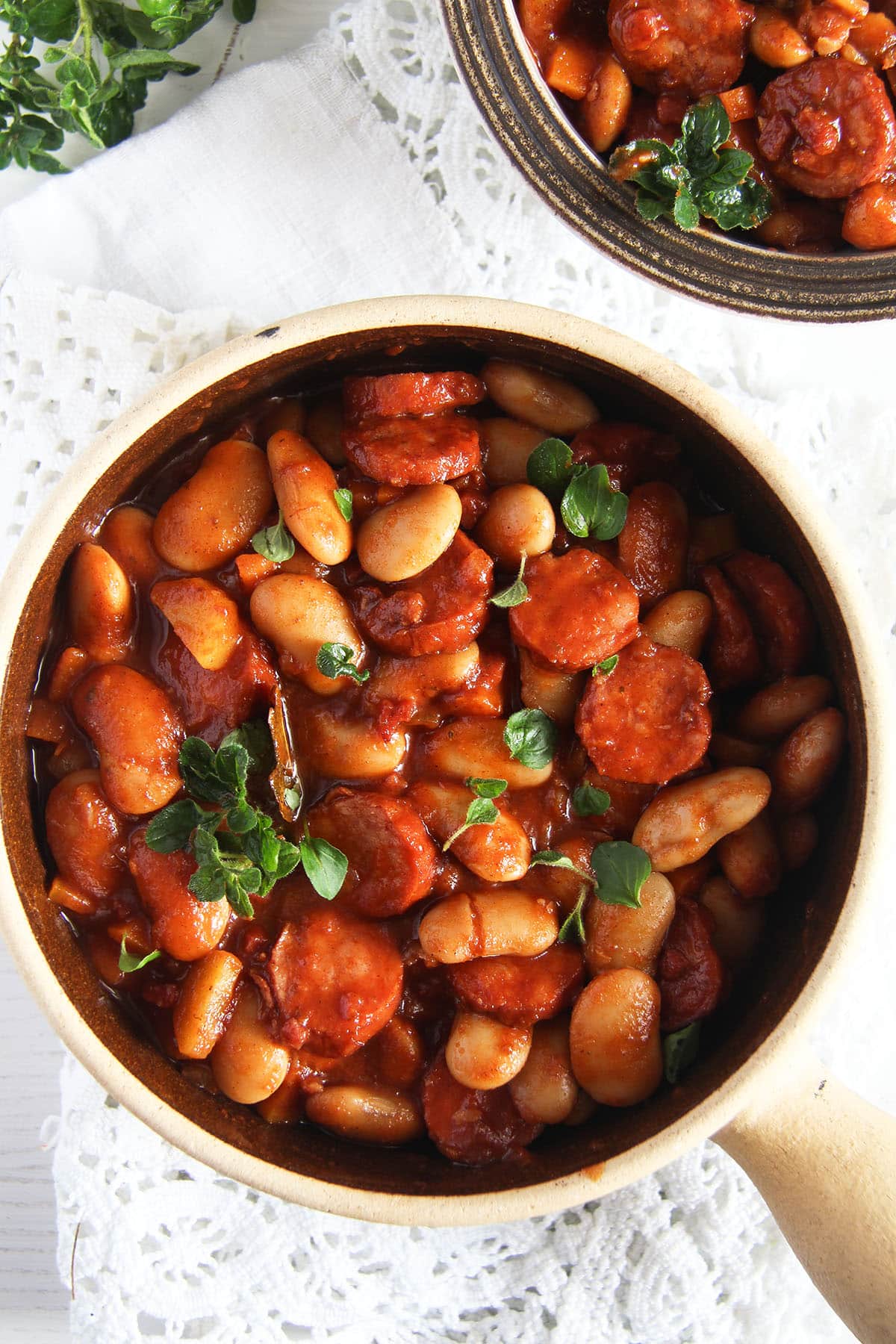 polish kabanoss stew with beans in a small clay pot.