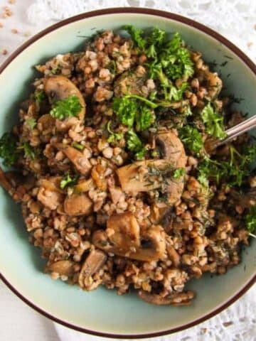 roasted buckwheat kasha in a blue bowl with a fork in it.