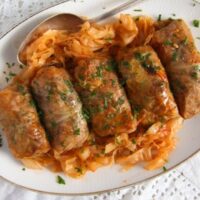 five sour cabbage rolls on a large serving platter