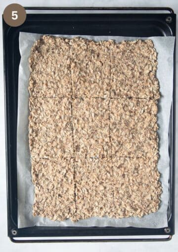 half-baked crispbread cut into pieces on a baking sheet.