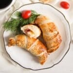 two and a half ham and cheese puff pastry croissants on a vintage plate.