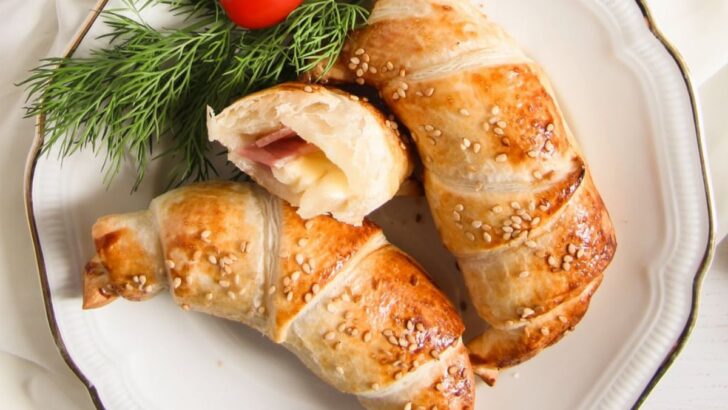 two and a half ham and cheese puff pastry croissants on a vintage plate.