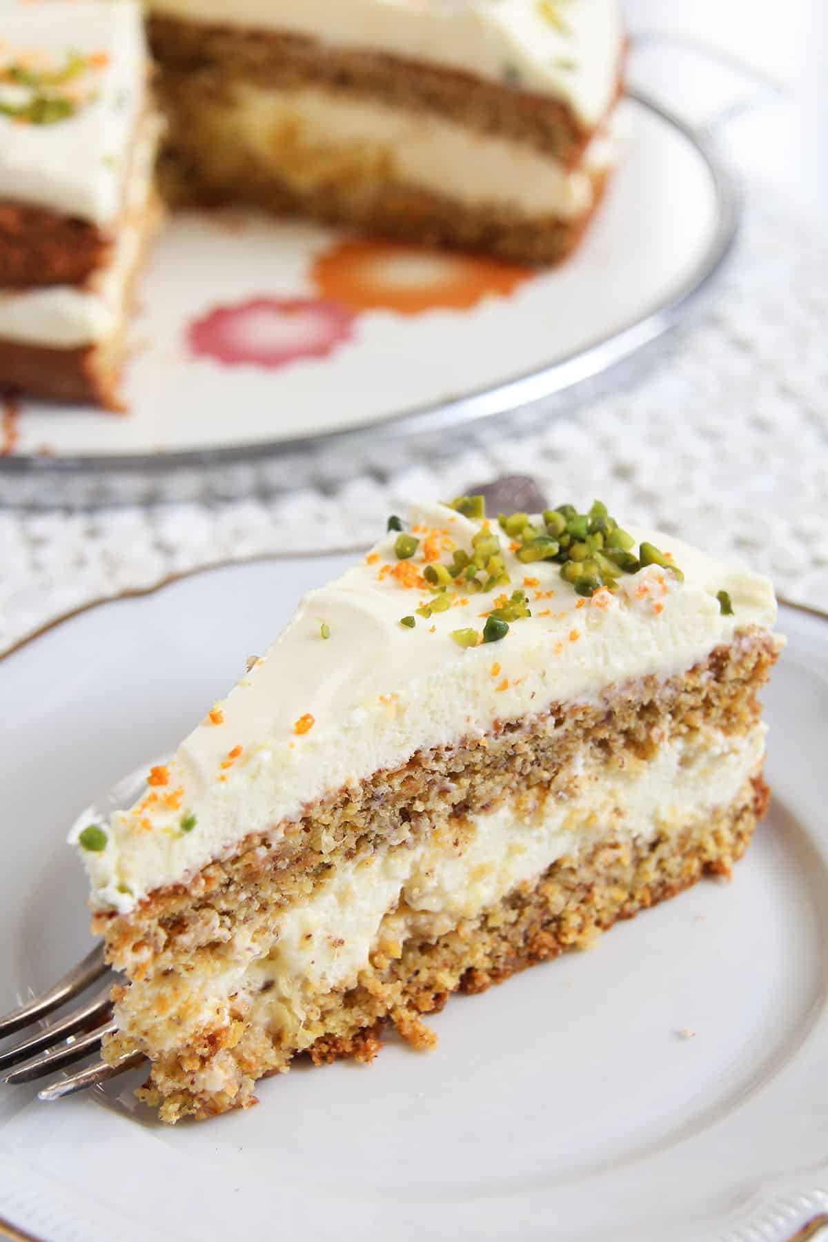 slice of layered carrot cake with almonds and orange cream filling. 