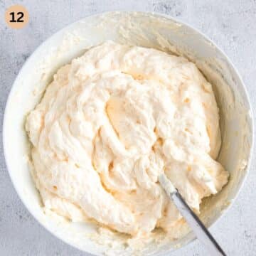 folding whipped cream into orange pudding to make a filling for carrot cake.