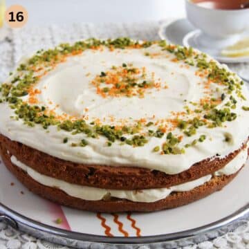 layered carrot cake with orange cream filling, decorated with orange zest and pistachios.
