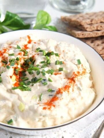 bowl of creamy breadspread with salad in the background