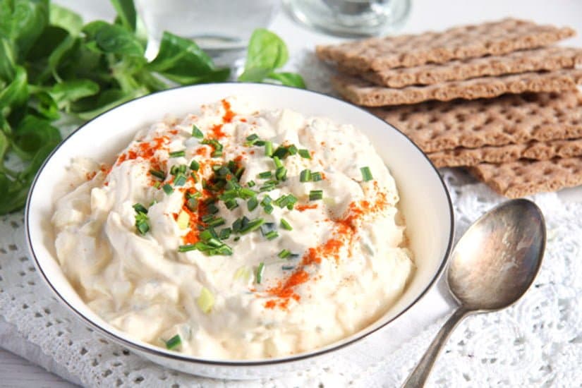 bowl of creamy breadspread with salad in the background