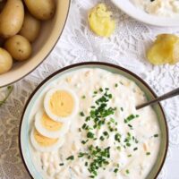 chopped eggs in yogurt sauce with chives served with potatoes