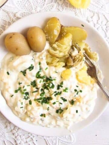 german egg salad served with boiled potatoes crushed with a fork on the plate.