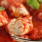close up of plate full of ricotta dumplings in tomato sauce