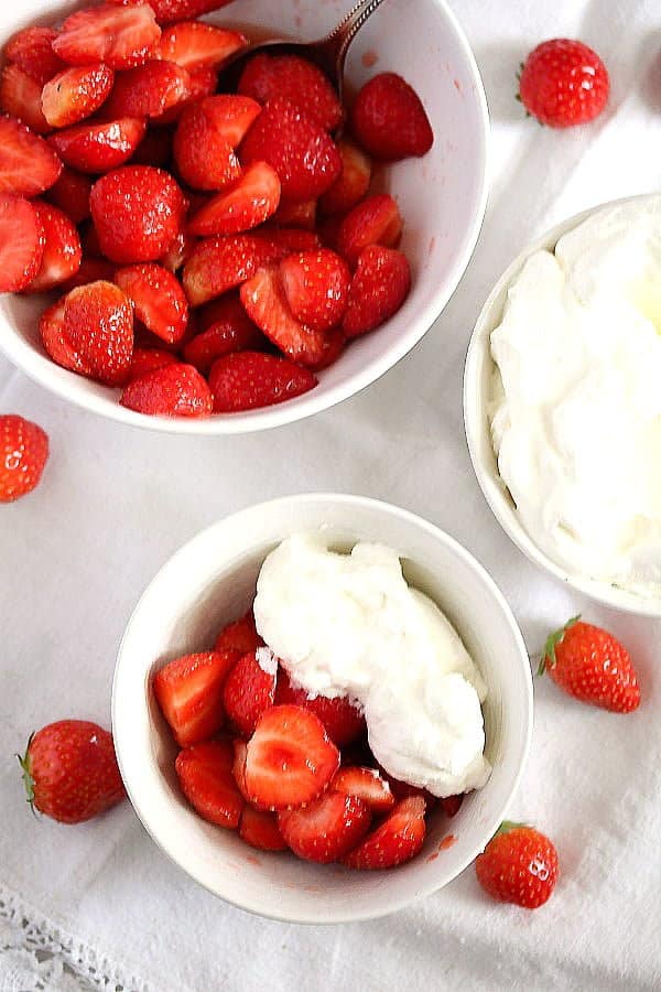 strawberries and whipped cream in a small serving bowl