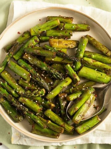 one plate of asparagus with garlic and sesame seeds.
