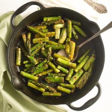 sauteed asparagus with garlic, ginger and soy sauce in a small cast iron skillet.