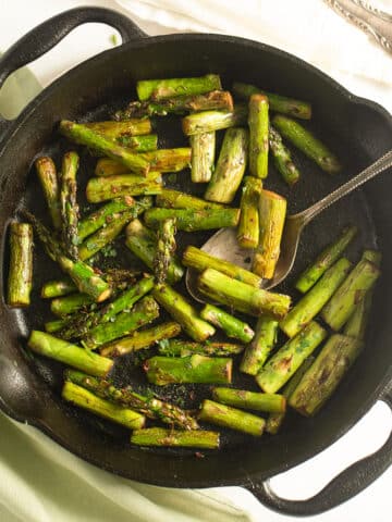 sauteed asparagus with garlic, ginger and soy sauce in a small cast iron skillet.