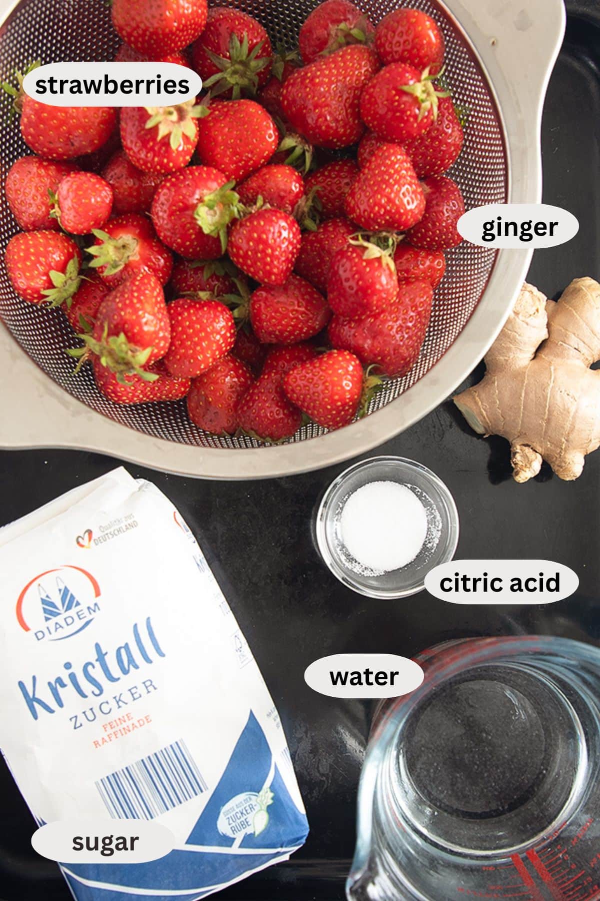 labeled ingredients for making syrup with fresh strawberries, sugar, ginger, and citric acid.