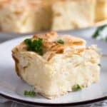 a square of serbian gibanica cheese pie sprinkled with parsley.
