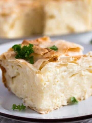 a square of serbian gibanica cheese pie sprinkled with parsley.