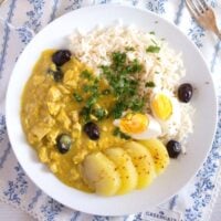 aji de gallina served with potatoes, hard-boiled eggs and rice.