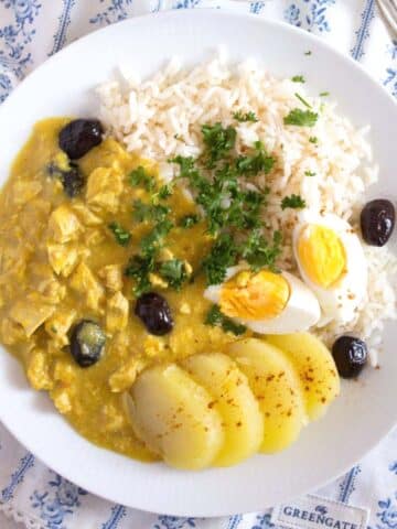 aji de gallina served with potatoes, hard-boiled eggs and rice