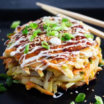 japanese bacon okonomiyaki drizzled with mayo and sprinkled with green onions.