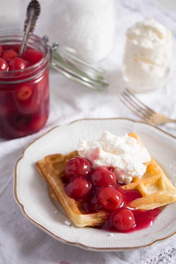 Belgian waffle with cherry sauce and whipped cream