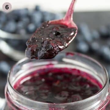 a spoon lifting blueberry sauce from a jar.