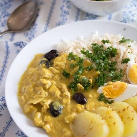 peruvian aji de gallina served with eggs and potatoes on a white plate