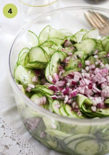 mixing cucumber slices and diced onion in a bowl.