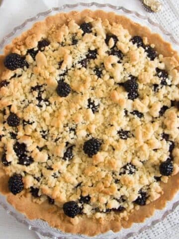 golden blackberry crumble pie on a serving platter.