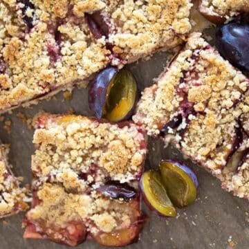 slices of zwetschgenkuchen and small plums on a baking tray.