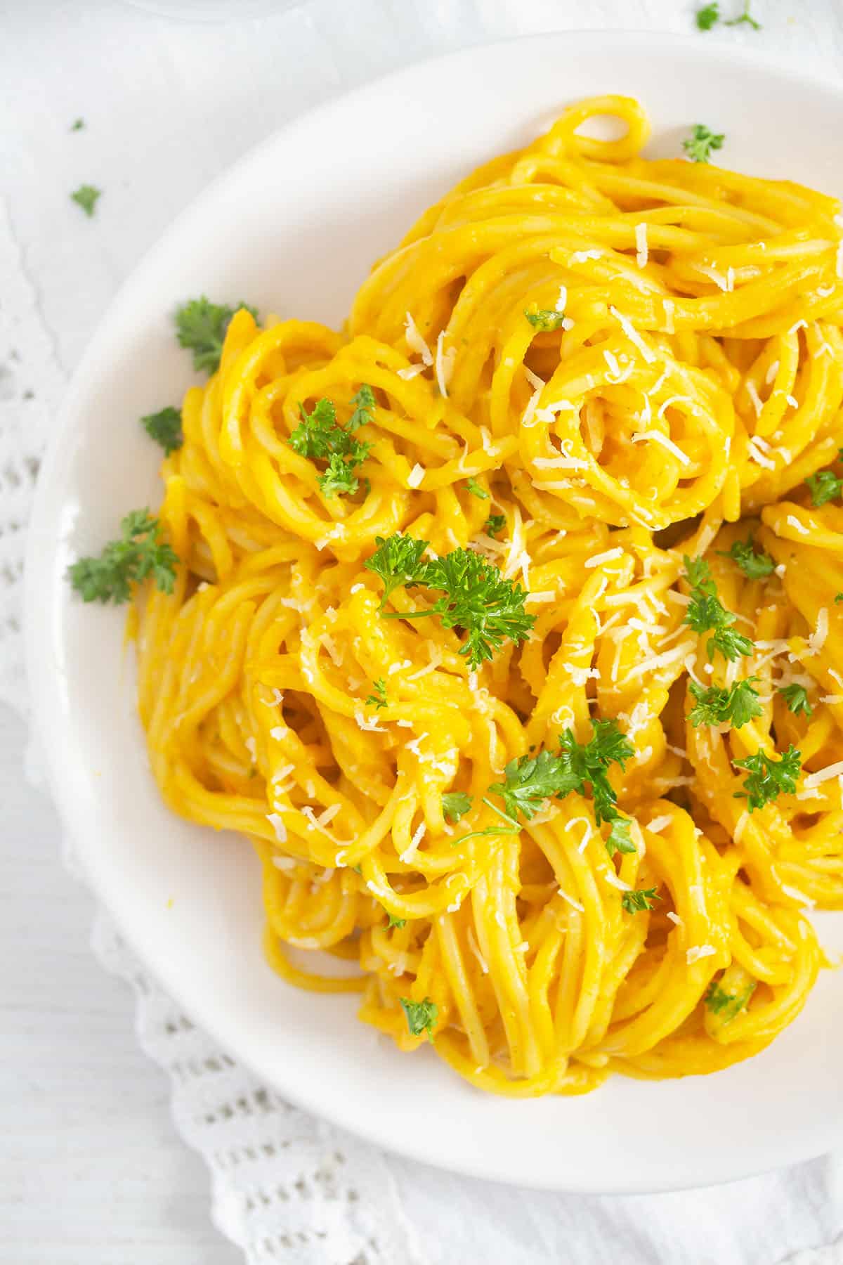 close up tangled, bright yellow spaghetti with pumpkin sauce.