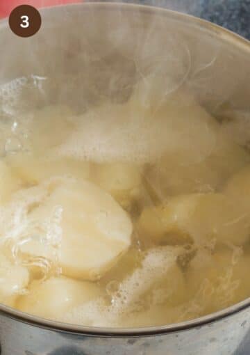 potato pieces cooking in a steamy pot.