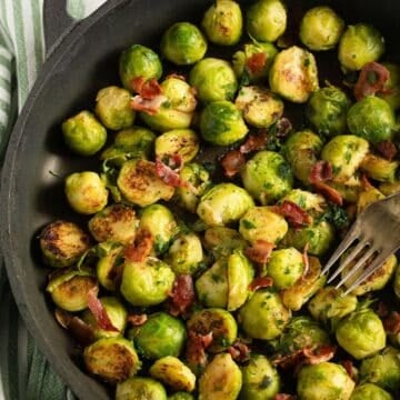 german brussels sprouts with bacon in a pan with a fork.