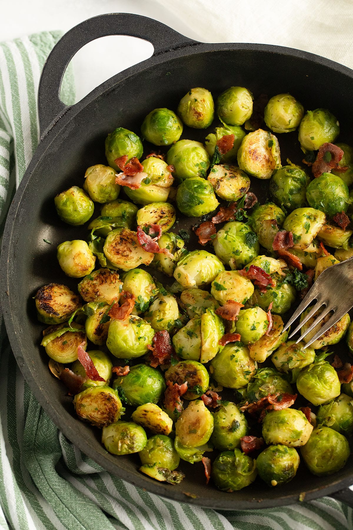 german brussels sprouts with bacon in a large frying pan.