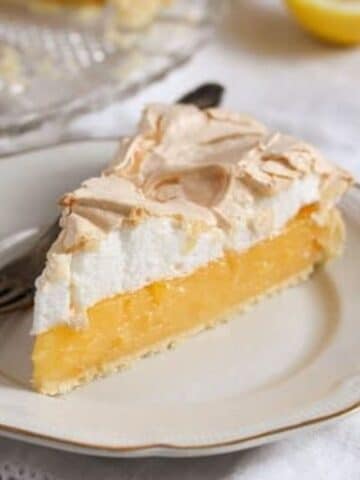 a slice of lemon merigue pie with thick golden filling.