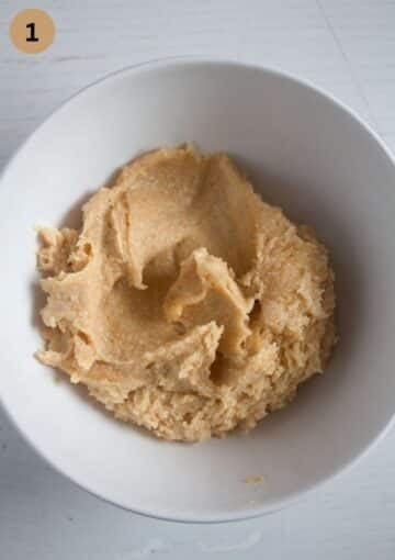 mixing ingredients for making peanut butter cookies in a bowl.