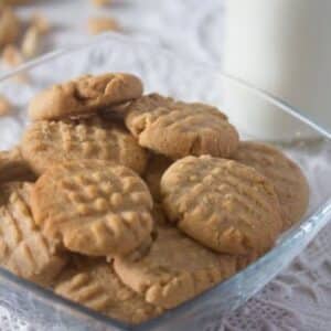 peanut butter cookies with peanuts in a small glass bowl.
