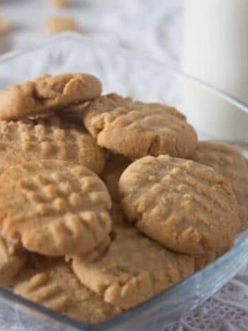 peanut butter cookies with peanuts in a small glass bowl.