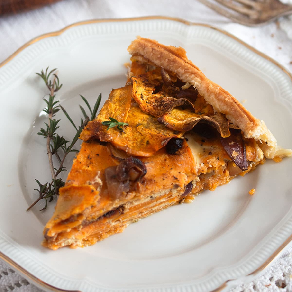 slice of savory sweet potato pie and tyhme on a plate.