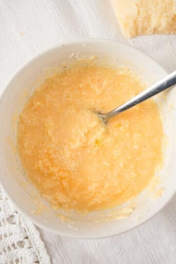 parmesan and egg yolk mixture for risotto in a small bowl with a fork.