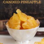 pinterest image of candied pineapple slices in a bowl.
