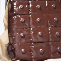 chocolate tray bake with shiny icing on a large baking tray seen from above