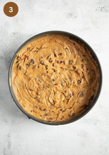 unbaked fruit cake with dried fruit in a cake pan.