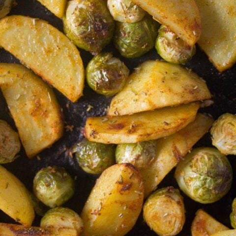 tender potato slices and brussels sprouts close up