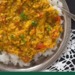 pinterest imag of yellow moong dal tadka on a silver plate.