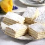 pieces of layered romanian lemon cake on a small plate.