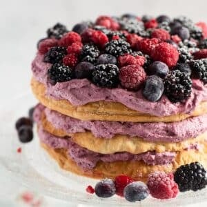 puff pastry cake layered with berry whipped cream and topped with fresh blueberries, blackberries and raspberries.