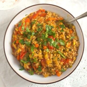 bowl with vegan kasha recipe with lots of vegetables and a fork sticking into it.