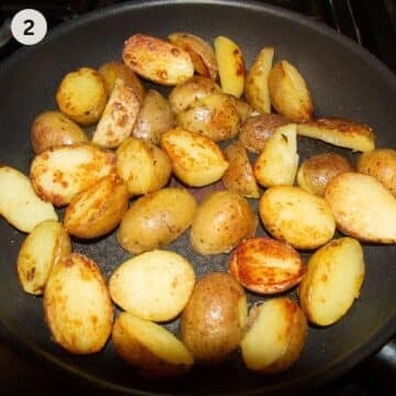 cooking halved fingerling potatoes in a skillet.